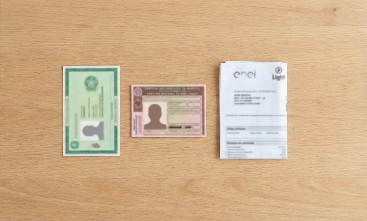 Documentos de identificação brasileiros organizados sobre mesa incluindo RG e CNH